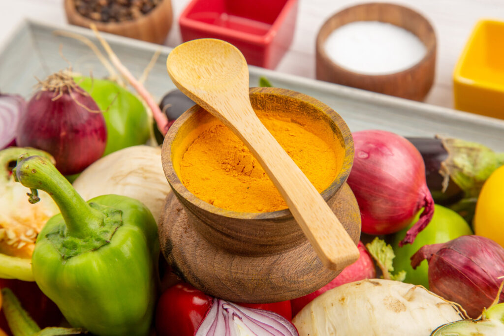 Un assortiment coloré d'épices (curcuma, gingembre, cannelle) disposées dans de petits bols.