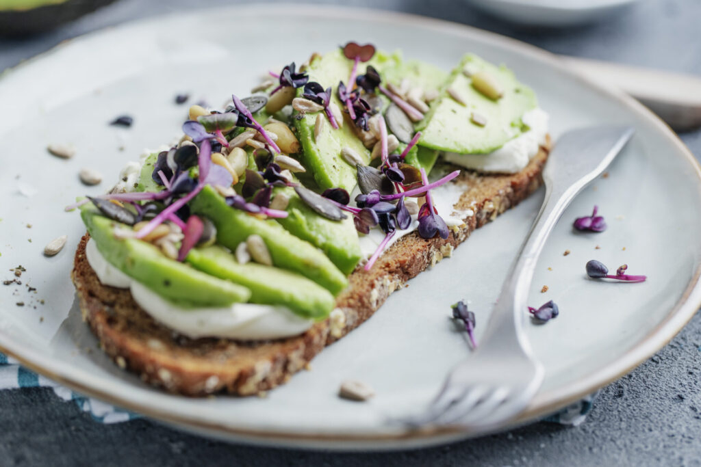 Un avocat coupé en tranches, ou une tartine à l'avocat crémeuse.